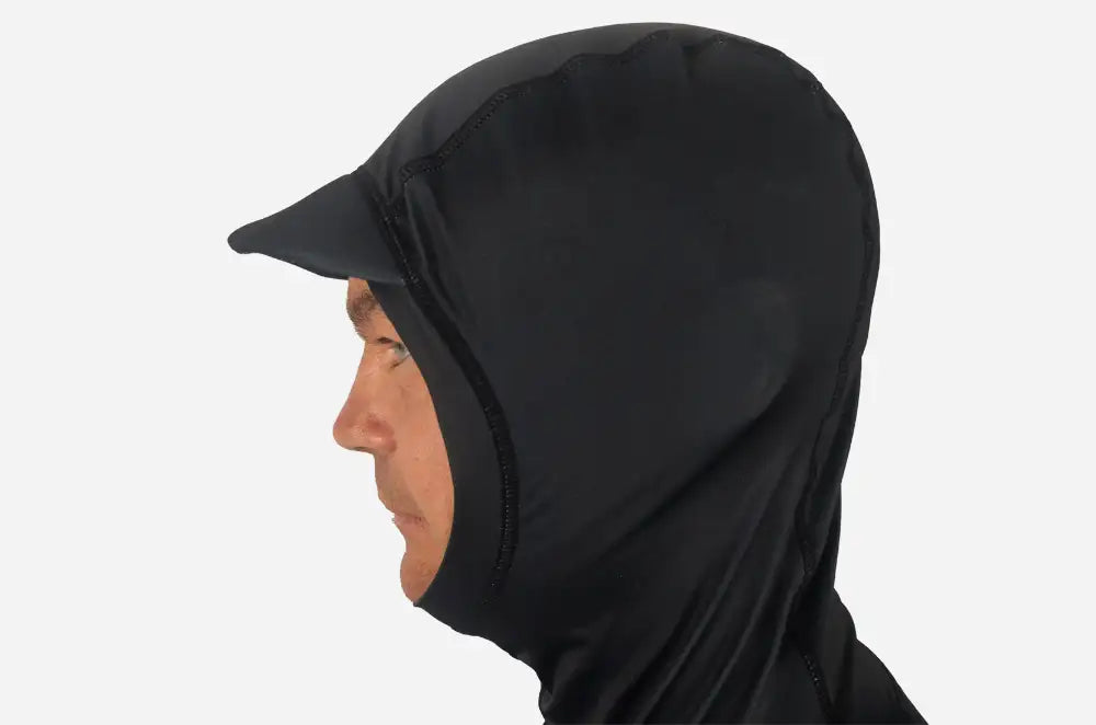 A man wearing a black full-head hooded rash vest for surfing with a sturdy peak, shown in profile against a plain white background.